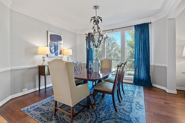 dining space featuring an inviting chandelier, ornamental molding, and dark hardwood / wood-style floors