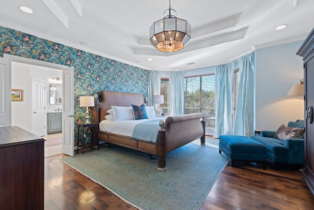 bedroom featuring dark hardwood / wood-style floors, ensuite bath, ornamental molding, and a raised ceiling