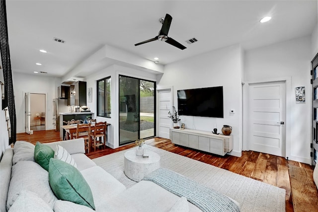 living room featuring hardwood / wood-style floors and ceiling fan