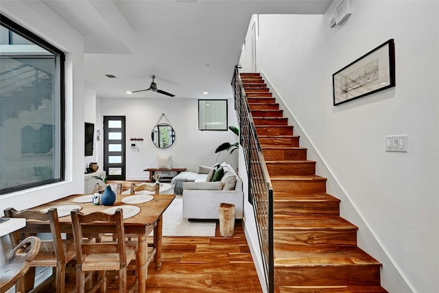 stairs with hardwood / wood-style flooring and ceiling fan