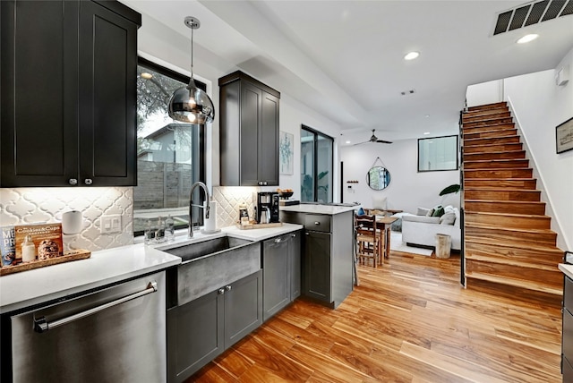 kitchen with sink, hanging light fixtures, tasteful backsplash, light hardwood / wood-style floors, and stainless steel dishwasher