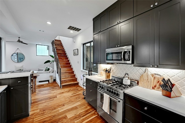 kitchen featuring tasteful backsplash, ceiling fan, appliances with stainless steel finishes, and light hardwood / wood-style floors