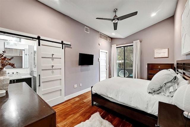 bedroom featuring vaulted ceiling, wood-type flooring, access to outside, ceiling fan, and a barn door