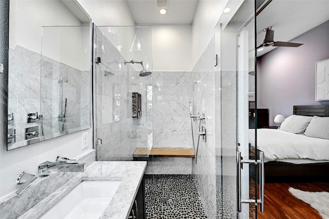 bathroom with hardwood / wood-style flooring, vanity, ceiling fan, and a shower with shower door