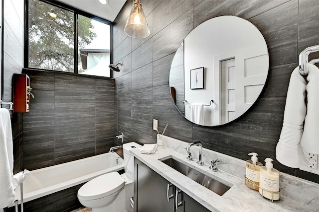 bathroom with a tub to relax in, toilet, vanity, and tile walls