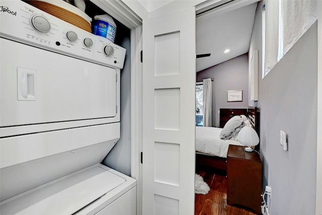 washroom with stacked washer / dryer and dark wood-type flooring