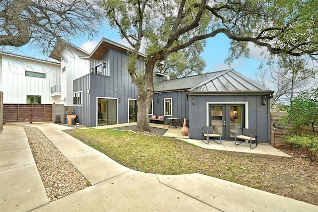 rear view of property with a patio, a yard, and french doors