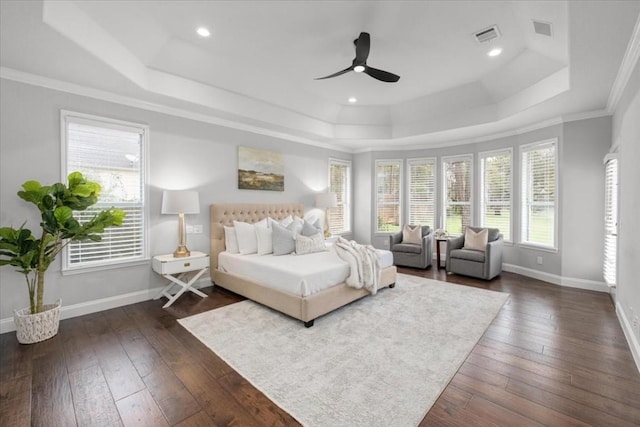 bedroom featuring dark wood-type flooring, ceiling fan, a tray ceiling, and crown molding