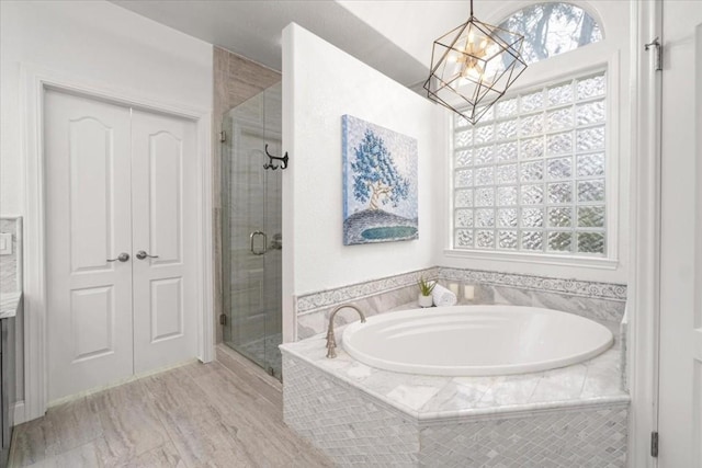 bathroom featuring plus walk in shower and a chandelier