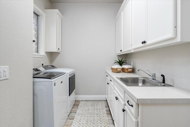 washroom featuring cabinets, sink, and washing machine and dryer