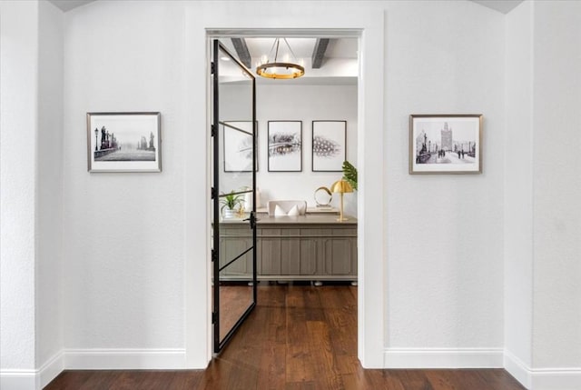 hallway featuring beam ceiling and dark wood-type flooring