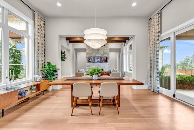 dining area with plenty of natural light, a fireplace, and light wood-type flooring