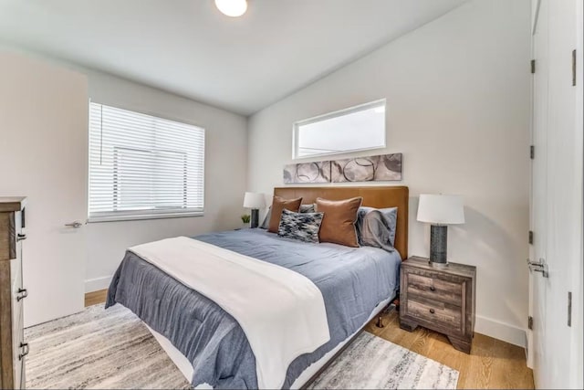 bedroom with lofted ceiling and light hardwood / wood-style floors