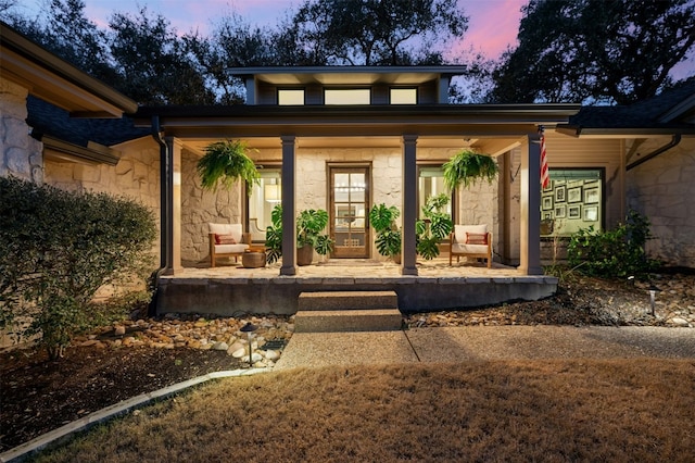 property entrance with a porch and stone siding