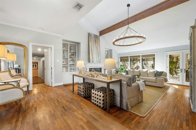 living room with an inviting chandelier, beam ceiling, hardwood / wood-style floors, and french doors