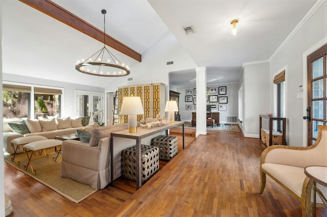 living room with crown molding, hardwood / wood-style floors, decorative columns, high vaulted ceiling, and a notable chandelier