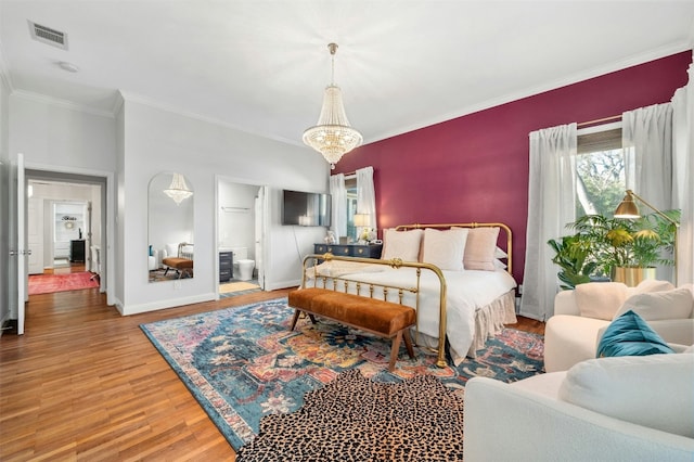 bedroom with ornamental molding, ensuite bathroom, hardwood / wood-style floors, and a notable chandelier