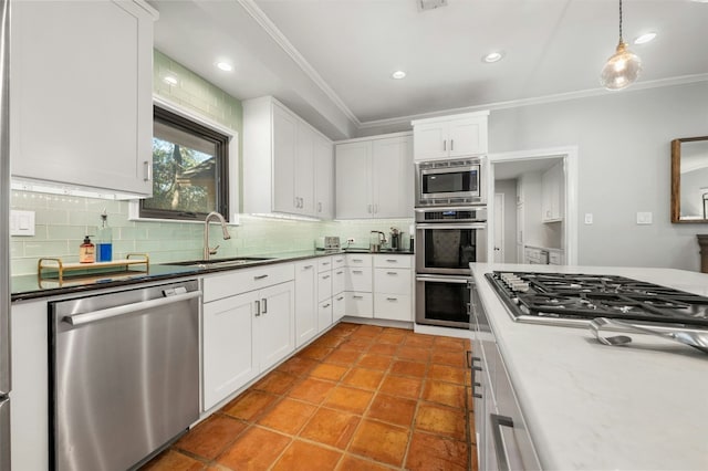 kitchen with white cabinetry, sink, ornamental molding, and appliances with stainless steel finishes