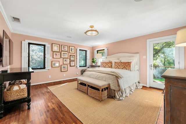 bedroom featuring access to exterior, dark hardwood / wood-style floors, multiple windows, and crown molding