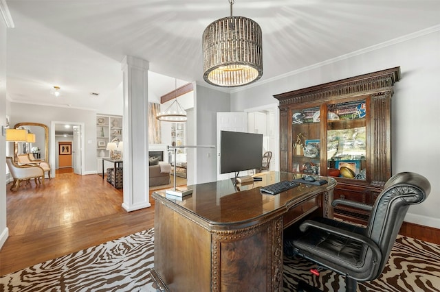 office space featuring crown molding, wood-type flooring, an inviting chandelier, and ornate columns