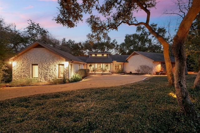 view of front of property with stone siding and a front lawn