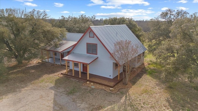 3959 Fm 535, Bastrop, TX 78602 - view of side of home with a porch, a metal roof, and a view of trees