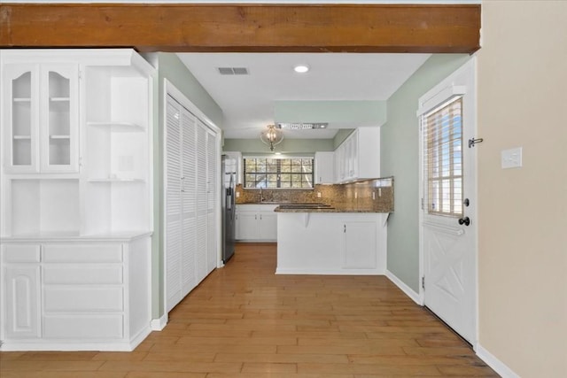 3959 Fm 535, Bastrop, TX 78602 - kitchen with white cabinetry, a peninsula, light wood-style flooring, stainless steel fridge with ice dispenser, and tasteful backsplash