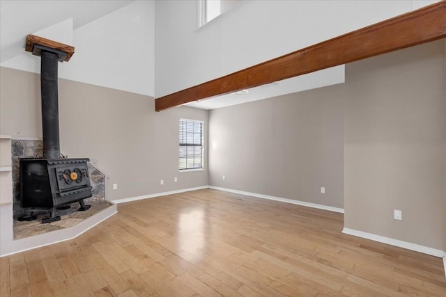 3959 Fm 535, Bastrop, TX 78602 - unfurnished living room featuring light wood finished floors, a towering ceiling, and a wood stove