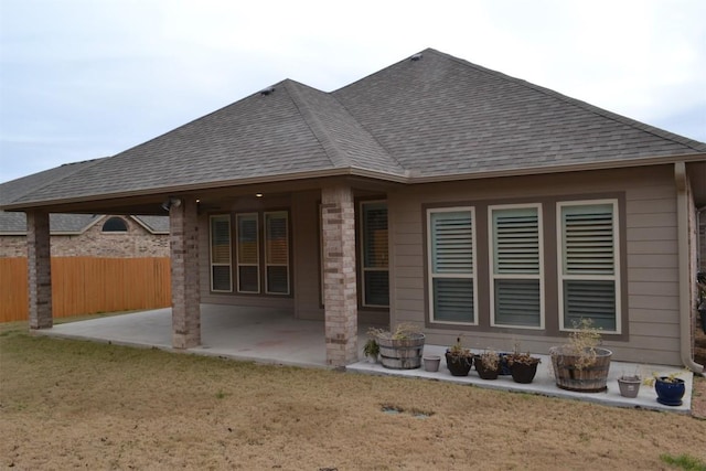 back of house with a lawn and a patio