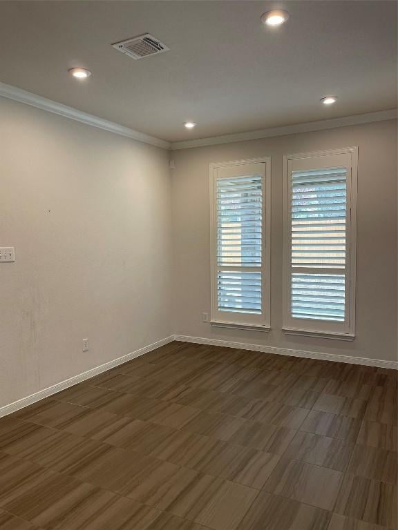 empty room featuring crown molding