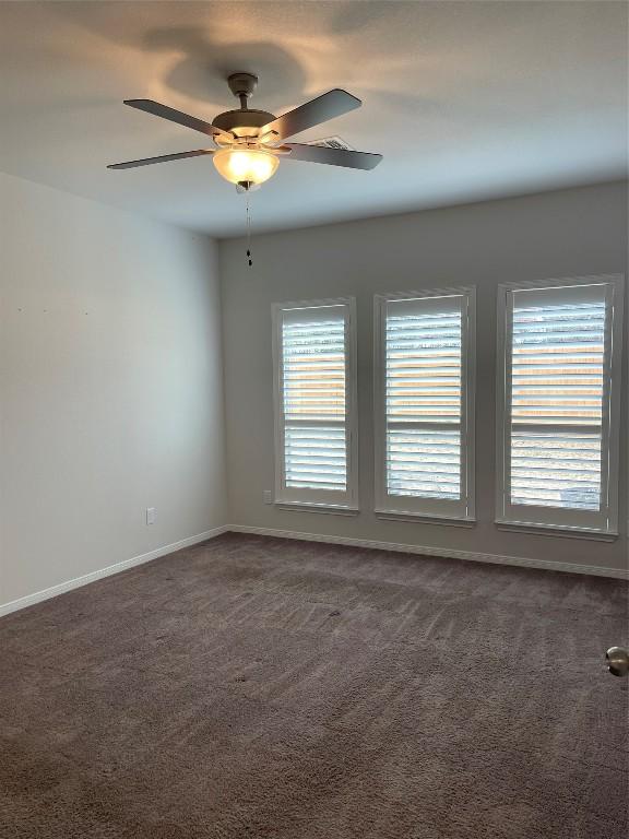 carpeted spare room with ceiling fan