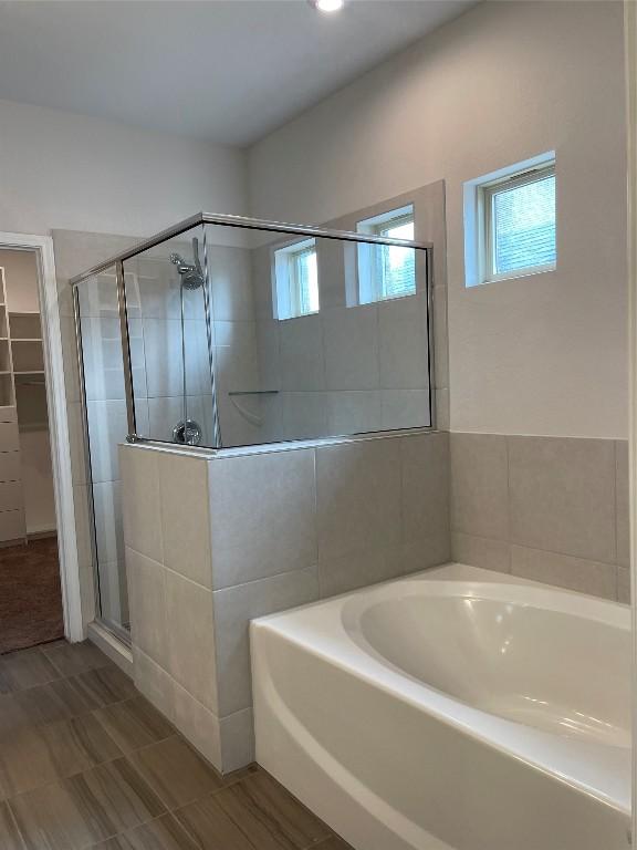 bathroom featuring shower with separate bathtub and plenty of natural light