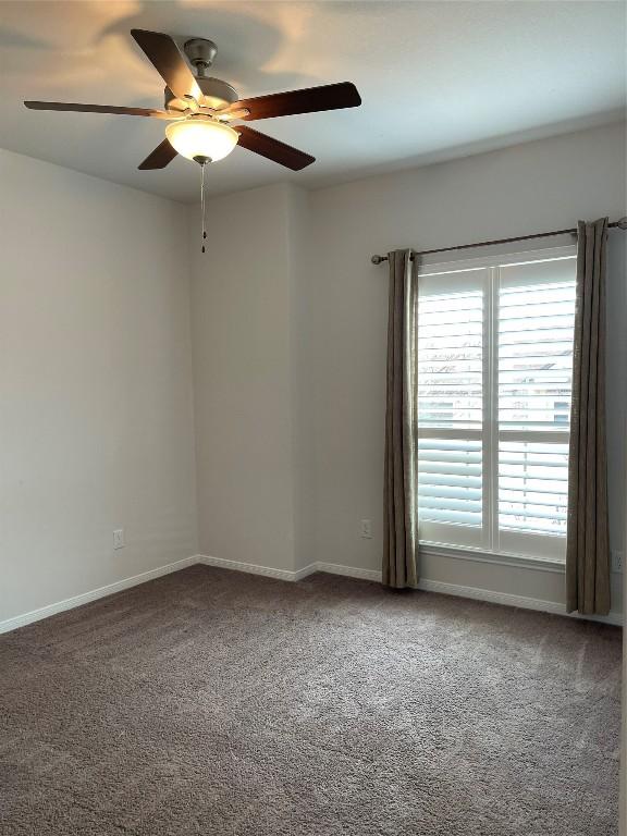 carpeted empty room featuring ceiling fan