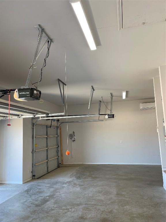 garage featuring a garage door opener and a wall mounted AC