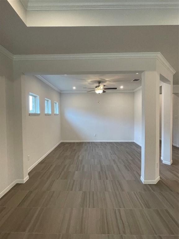 unfurnished living room with dark wood-type flooring, ornamental molding, and ceiling fan