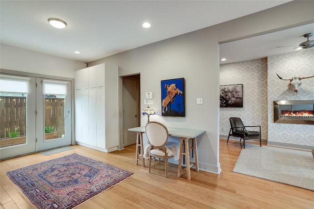 1109 Holly St Unit B, Austin, TX 78702 - foyer featuring wallpapered walls, a large fireplace, wood finished floors, a ceiling fan, and baseboards