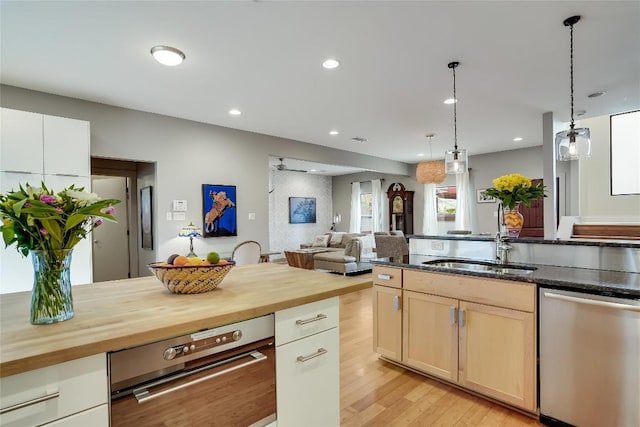 1109 Holly St Unit B, Austin, TX 78702 - kitchen featuring stainless steel dishwasher, wooden counters, a sink, light wood finished floors, and recessed lighting