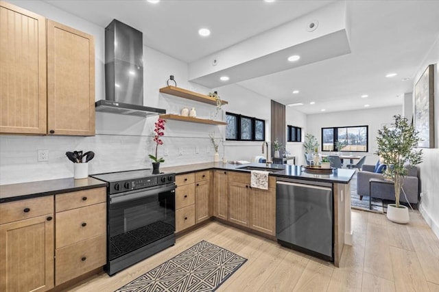 kitchen featuring wall chimney exhaust hood, black electric range oven, sink, stainless steel dishwasher, and kitchen peninsula