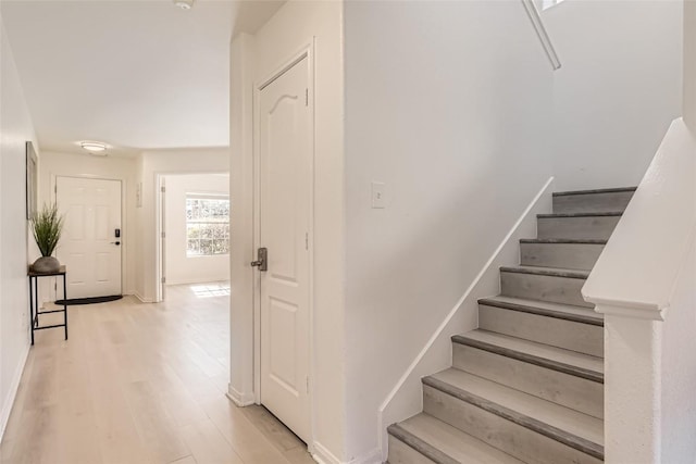 staircase with wood finished floors and baseboards