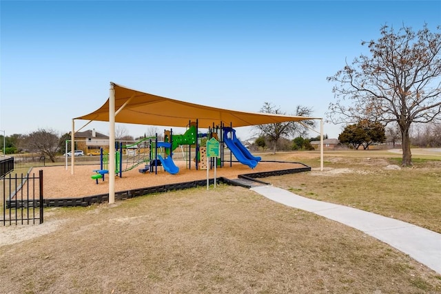 community jungle gym with a lawn and fence