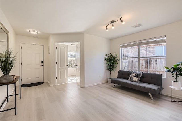 foyer with baseboards, visible vents, and light wood finished floors