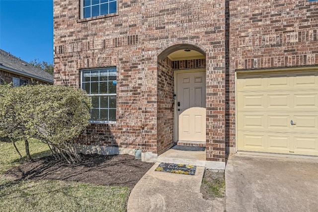 entrance to property with brick siding and an attached garage