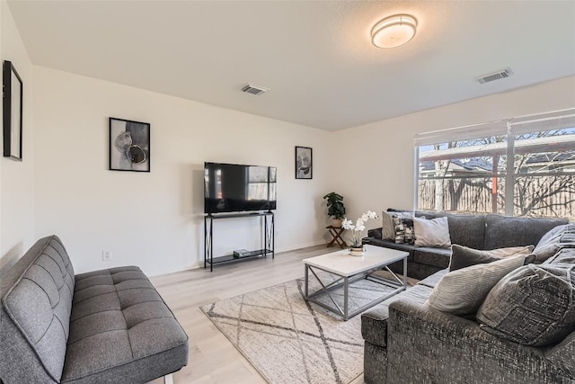 living room with visible vents and light wood-style floors