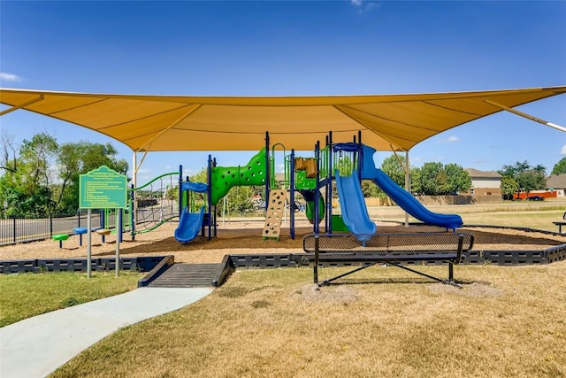 communal playground featuring fence and a lawn