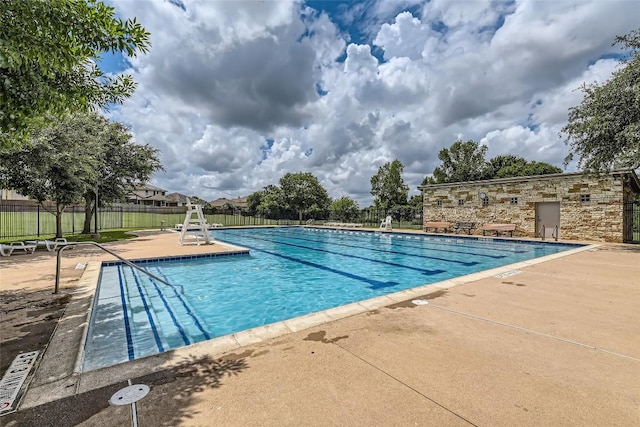 community pool featuring a patio and fence