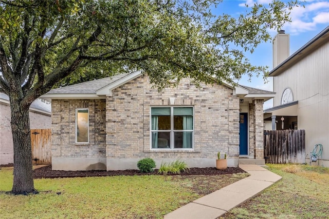 view of front facade featuring a front lawn and fence