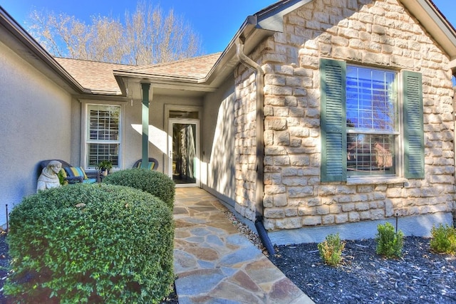 104 Grapevine Ln, Georgetown, TX 78633 - view of exterior entry featuring stone siding, stucco siding, and roof with shingles