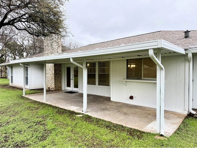 12104 Sage Hen Cir, Austin, TX 78727 - back of house with french doors, a patio area, roof with shingles, a chimney, and a yard