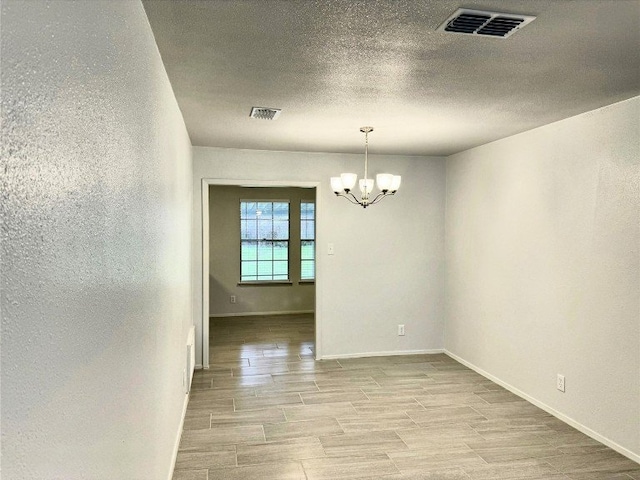 12104 Sage Hen Cir, Austin, TX 78727 - spare room featuring a chandelier and light wood-type flooring