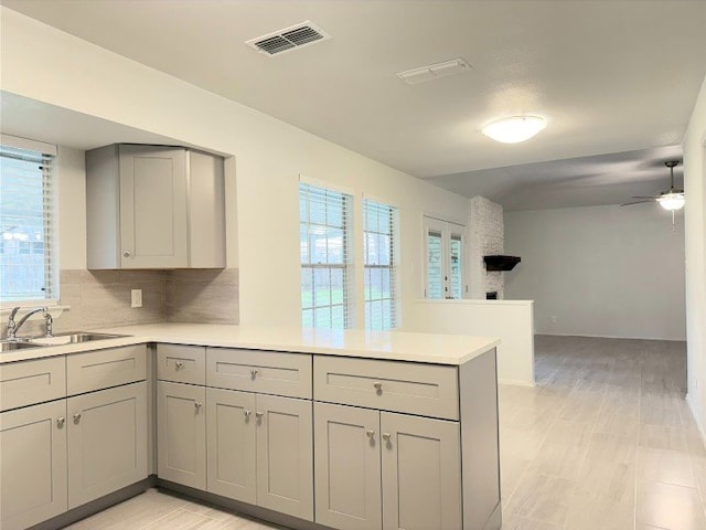 12104 Sage Hen Cir, Austin, TX 78727 - kitchen with gray cabinetry, a peninsula, light countertops, and a ceiling fan